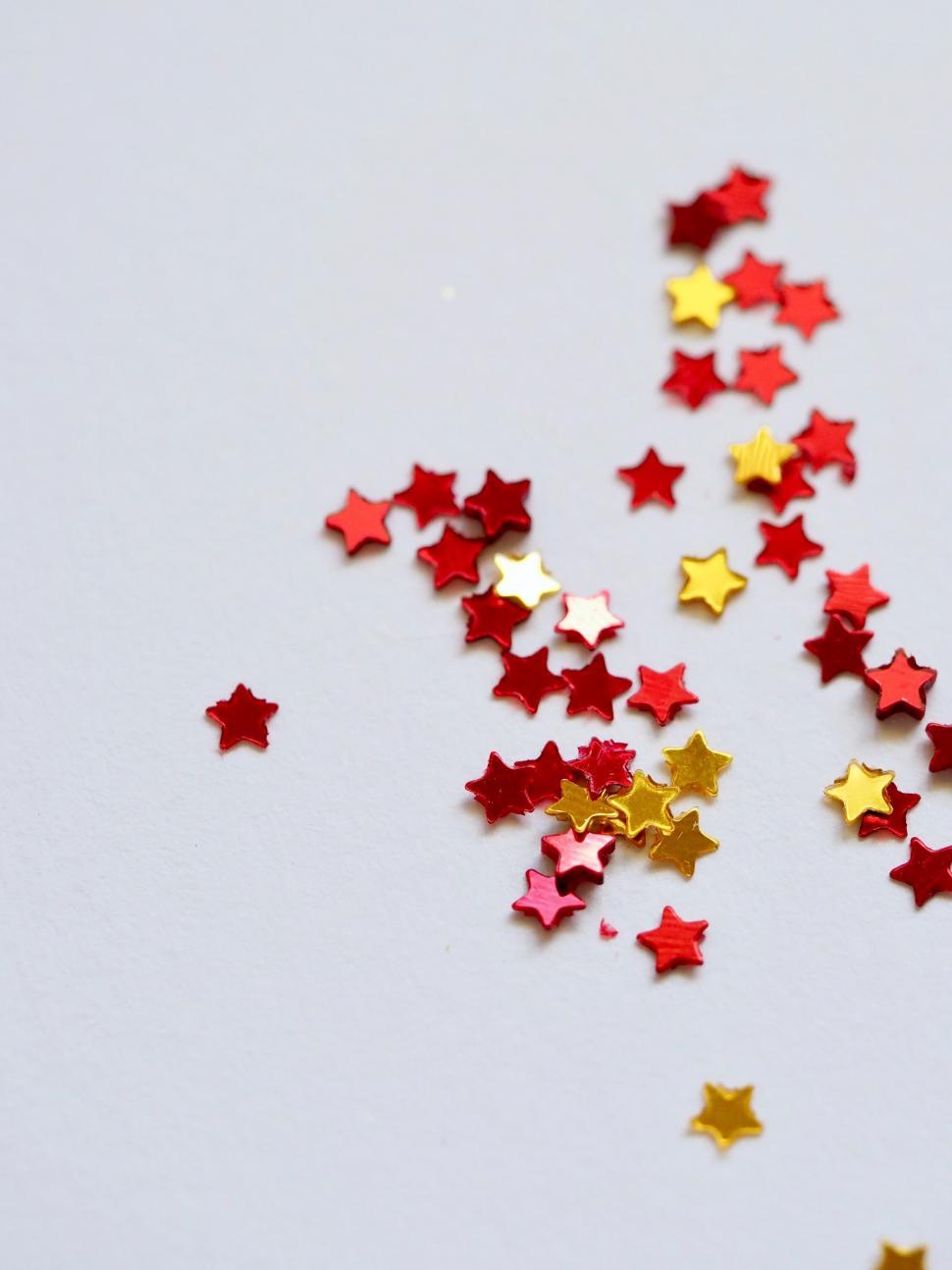 Free Image of Red and gold star confetti on light background 