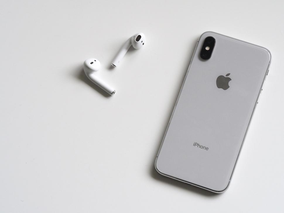 Free Image of Apple iPhone and wireless earbuds on white 