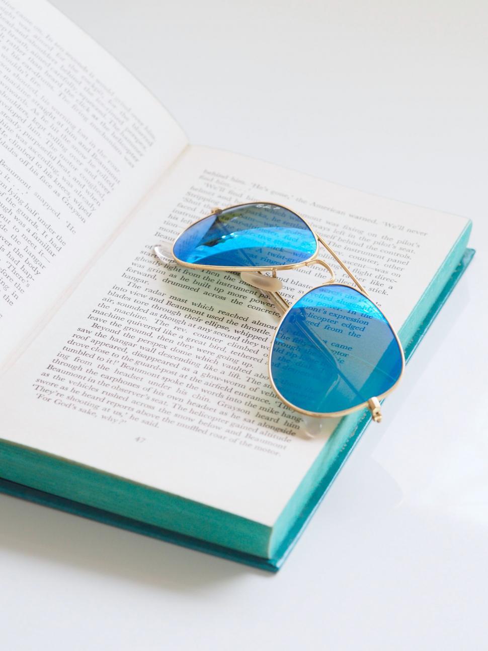 Free Image of Open book with sunglasses on page 