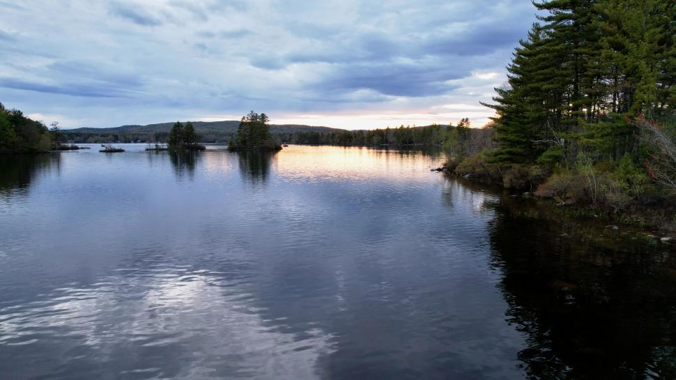 Free Image of Serene lake at sunset with trees and sky 