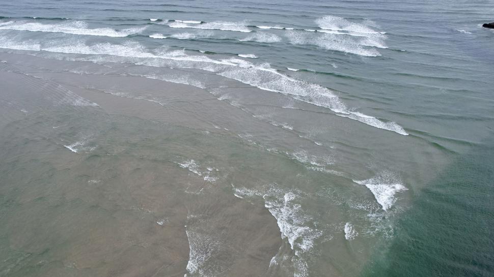 Free Image of Ocean waves approaching sandy beach 