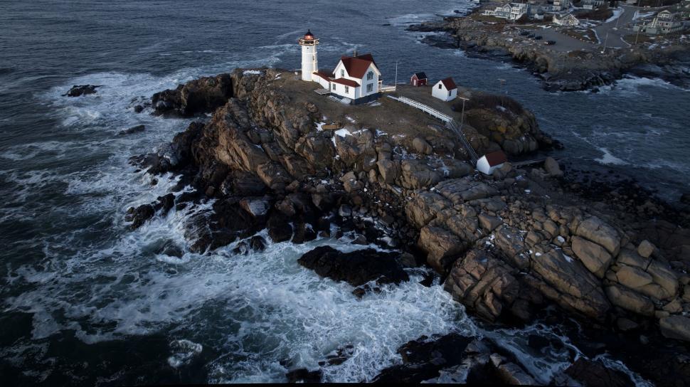 Free Image of Lighthouse on rocky coastline at dusk 
