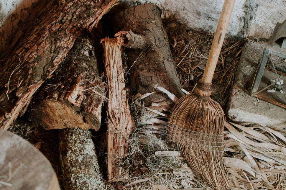 Free Image of Old Broom and Firewood Inside a Shed 