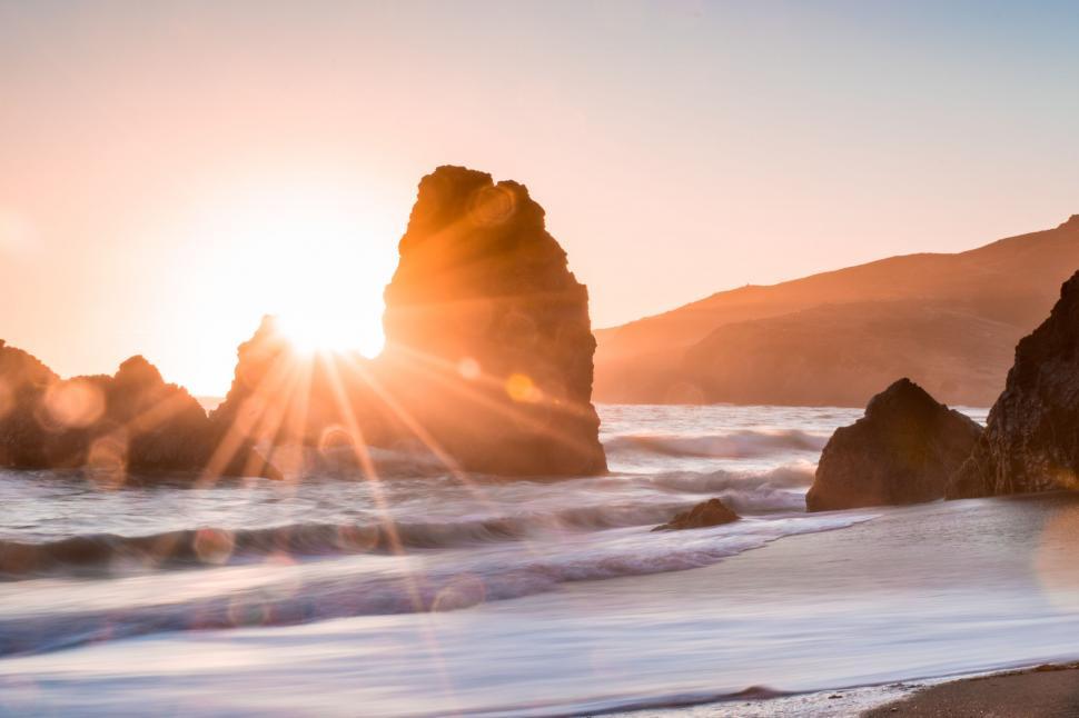 Free Image of Rocky coastline bathed in golden sunset light 