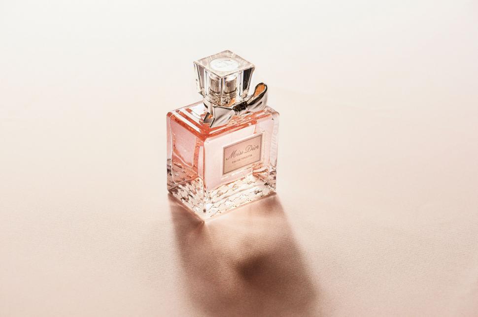 Free Image of Elegant perfume bottle on a pink surface 