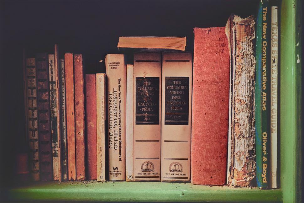 Free Image of Vintage books on a shelf with warm light 