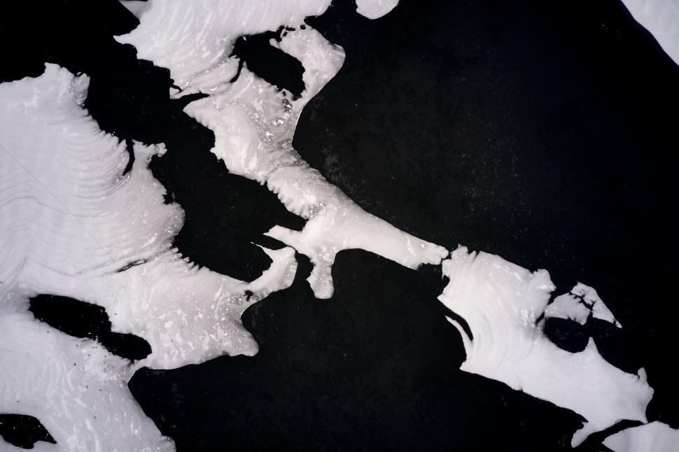 Free Image of Aerial view of ice formations on dark water surface. 