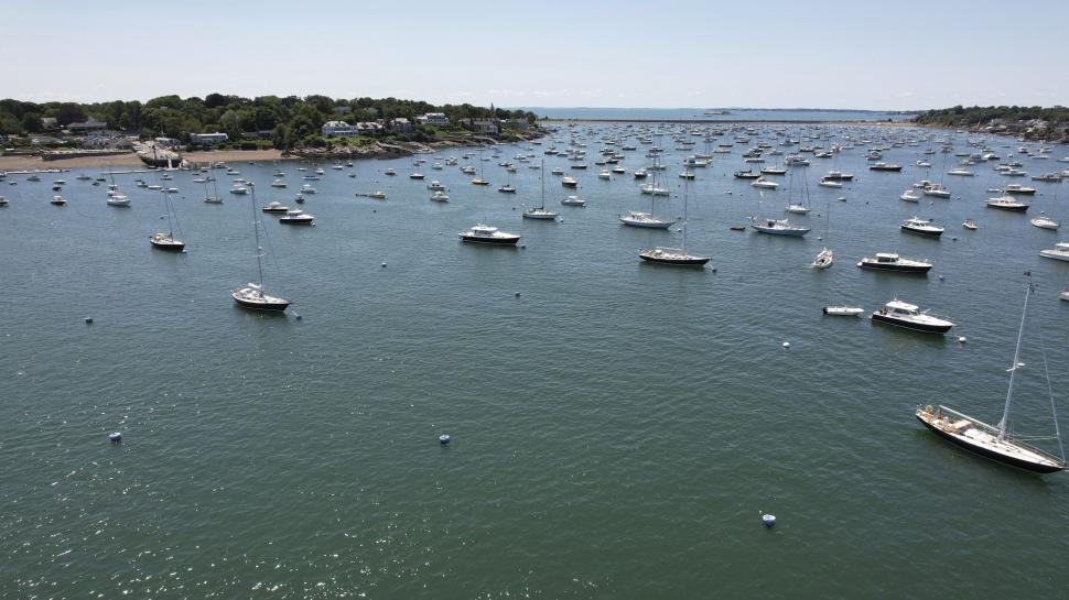 Free Image of Numerous sailboats anchored in sunny coastal bay 