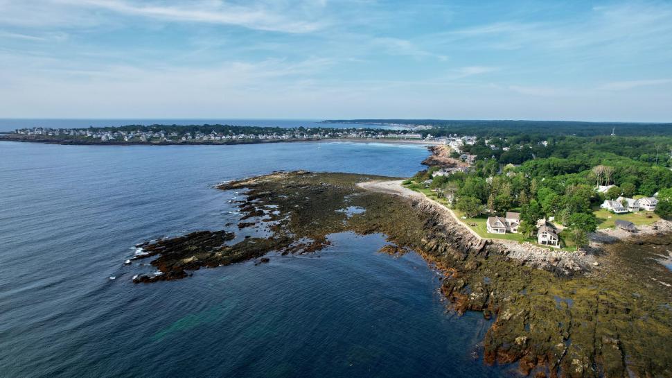 Free Image of Coastal town panorama with rocky shoreline and ocean view 
