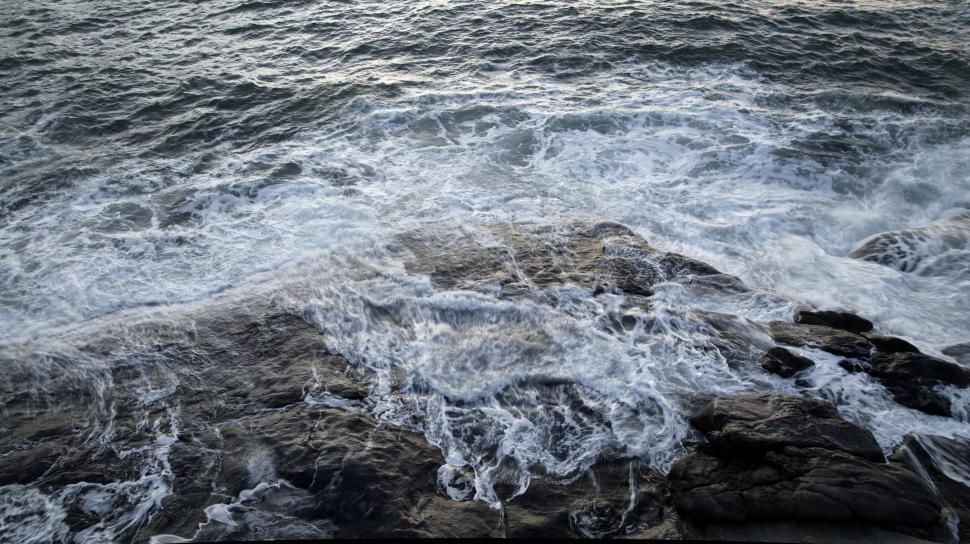Free Image of Powerful ocean waves crashing over rocky shoreline 