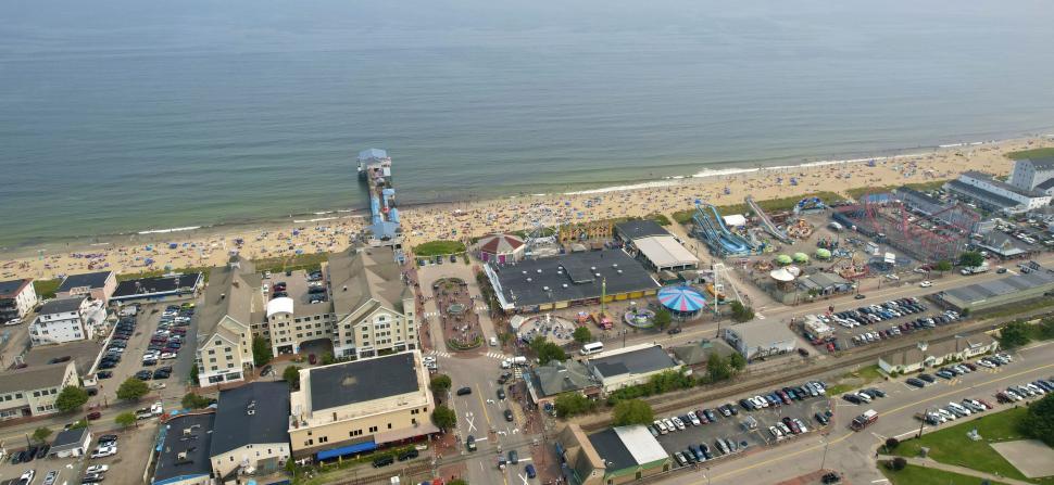 Free Image of Busy beach with amusement park and vacationers aerial view 