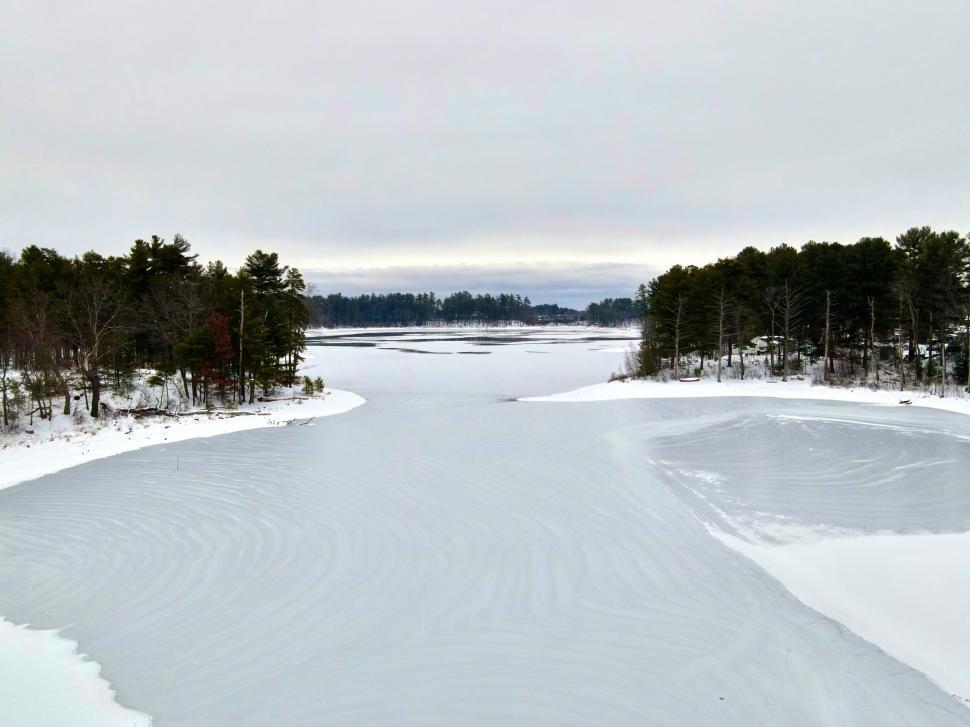 Free Image of Frozen lake with snowy surroundings and trees, winter. 