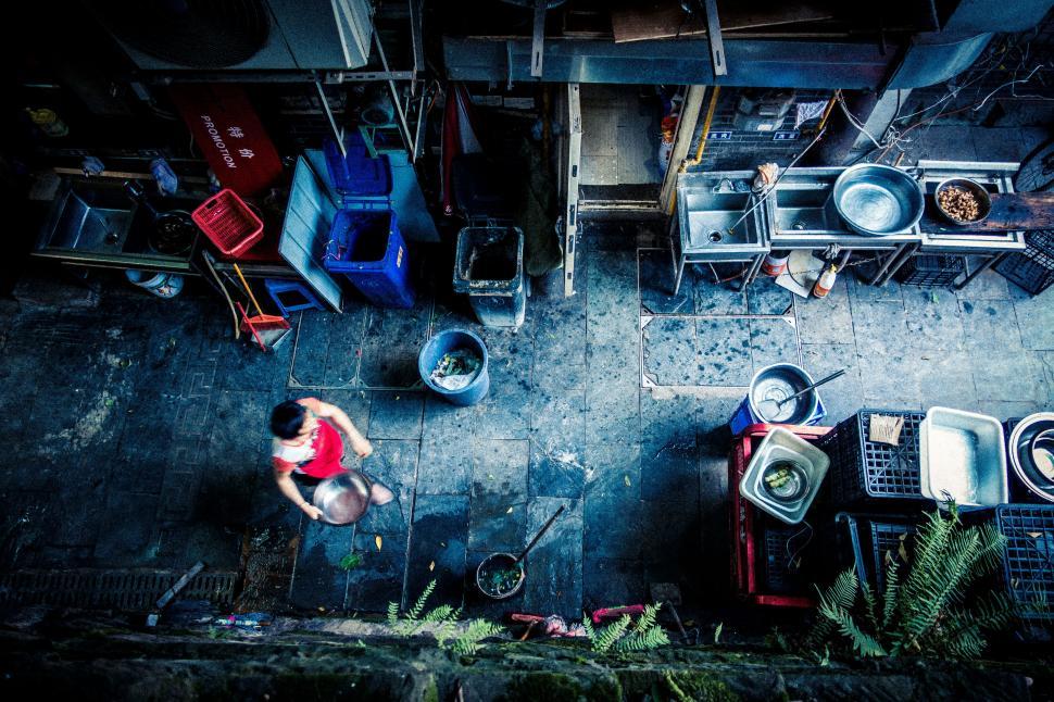 Free Image of Aerial view of alley with lone person amidst utensils 