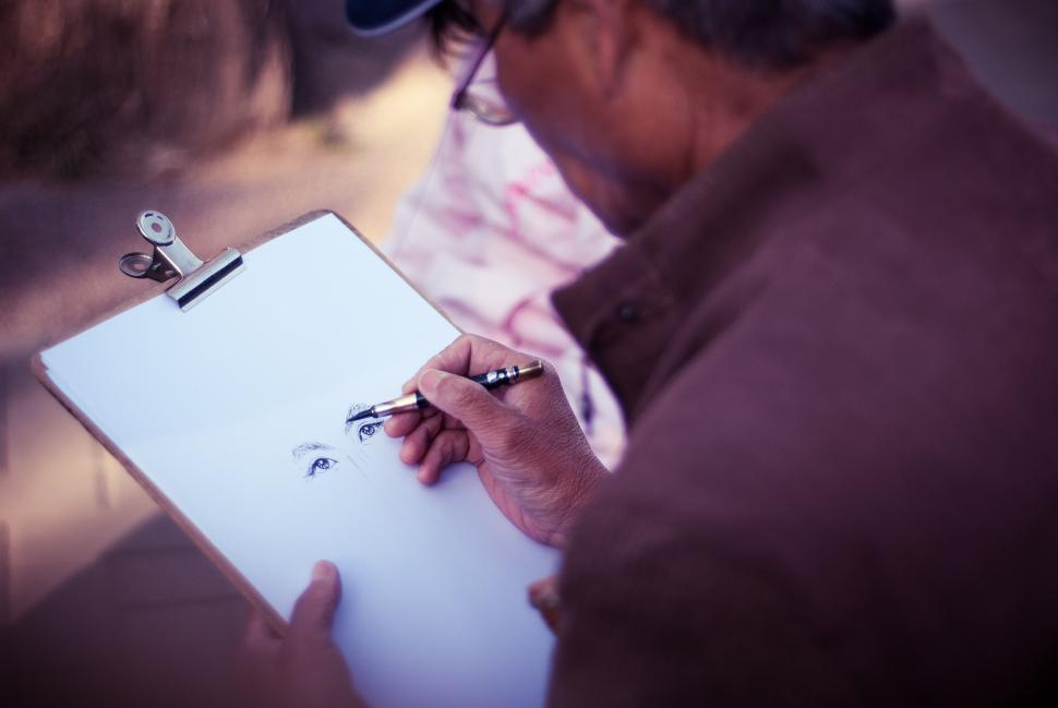 Free Image of Artist drawing portrait with focus on detailed eyes 