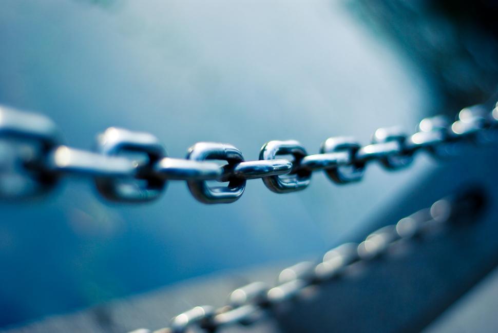 Free Image of Detailed close-up of metal chain links against blue 