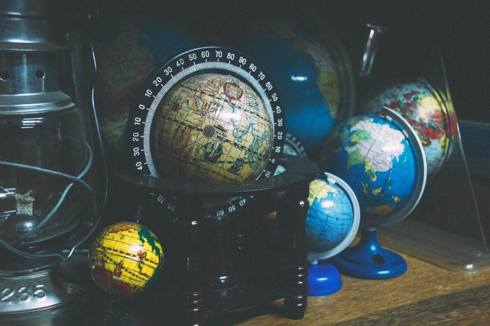Free Image of Various colorful globes on wooden surface display shelf. 