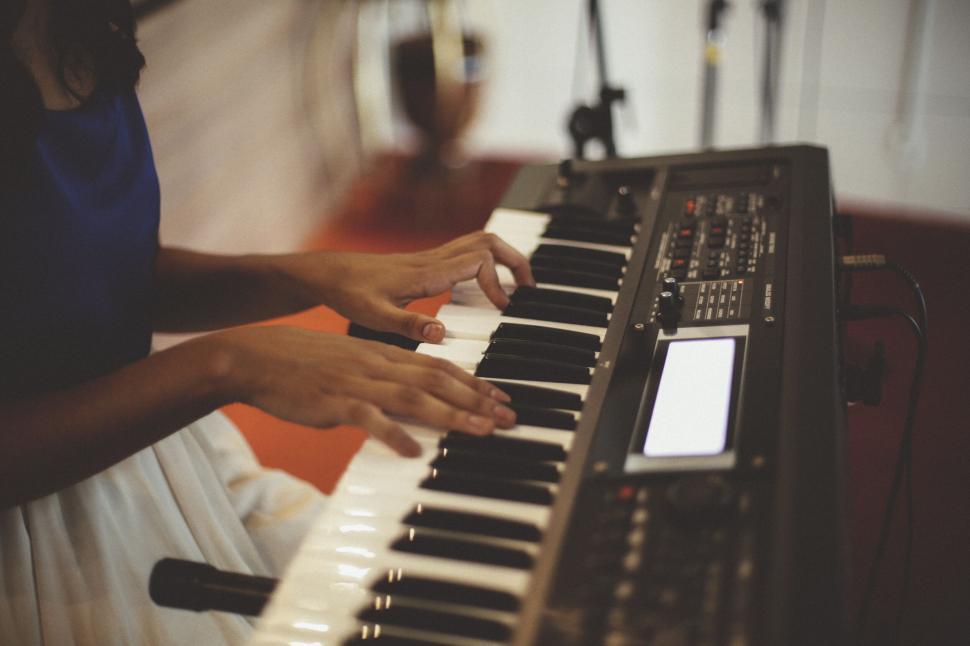 Free Image of Person playing a keyboard piano in music studio setting 
