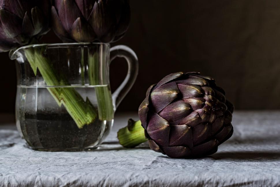 Free Image of Elegantly arranged purple artichokes in glass pitcher 