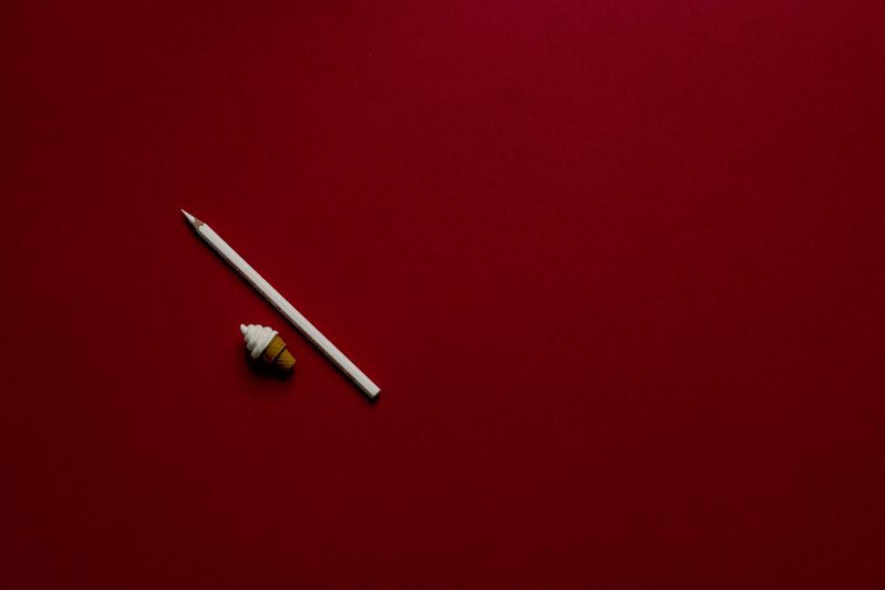 Free Image of Pencil and seashell on red background minimalistic scene 