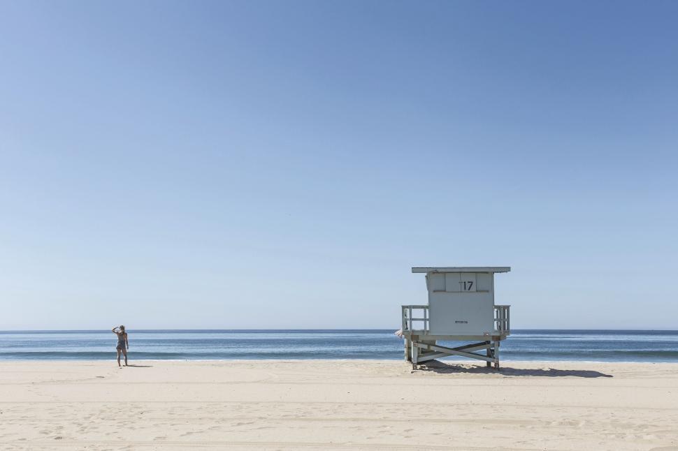 Free Image of Lifeguard tower on a sandy beach with clear sky. 