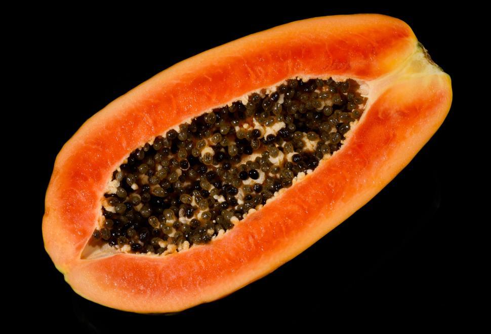 Free Image of Halved ripe papaya with black seeds on dark background. 