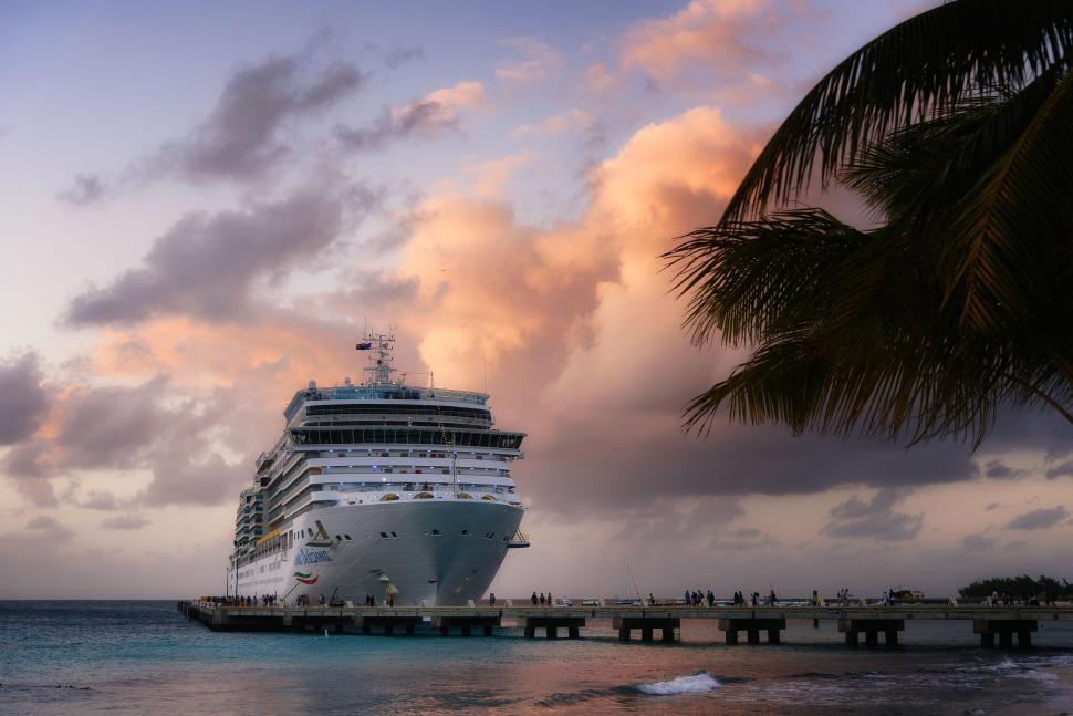 Free Image of Large white cruise ship docked under a colorful sunset sky 