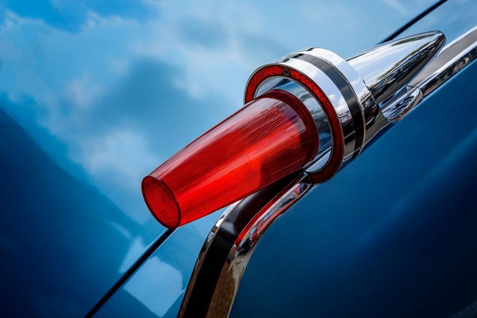 Free Image of Red tail light of a classic vintage car shining vividly. 