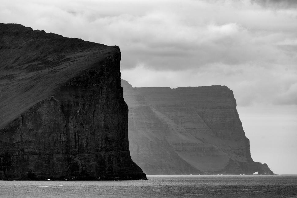 Free Image of Majestic cliffs standing strong by the calm ocean. 