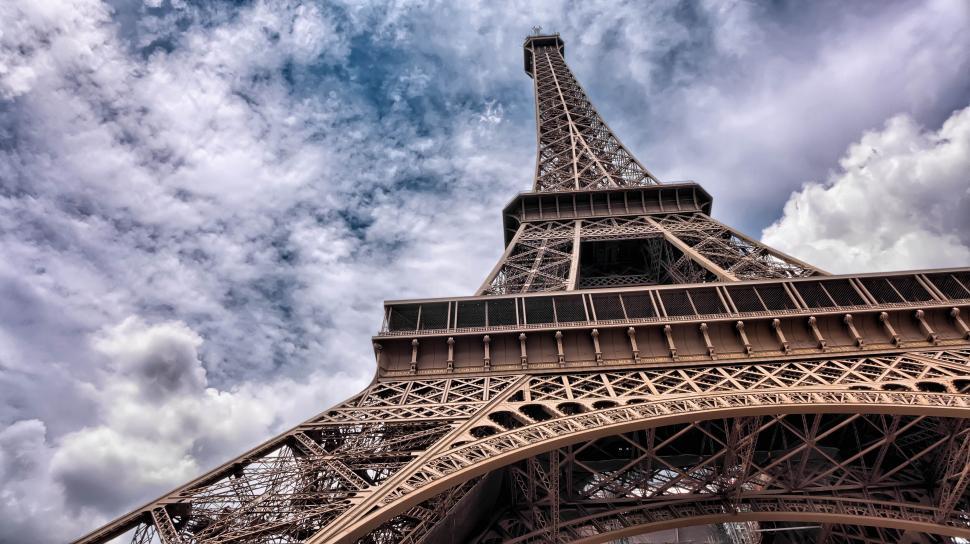 Free Image of Close-up view of the Eiffel Tower with clouds above. 