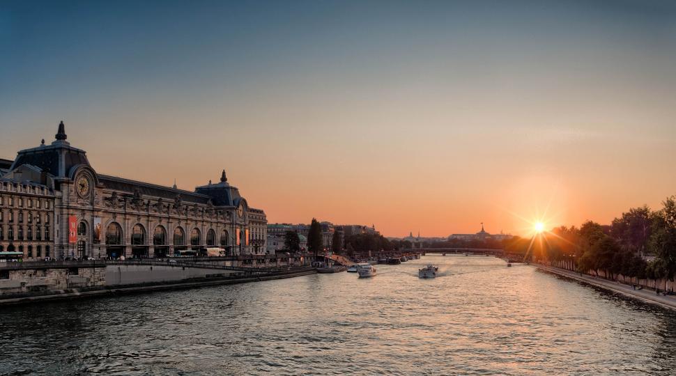 Free Image of Sunset view of a historic riverside European cityscape. 