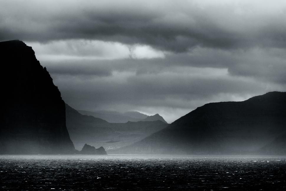 Free Image of Dramatic seascape with dark mountains and misty horizon. 