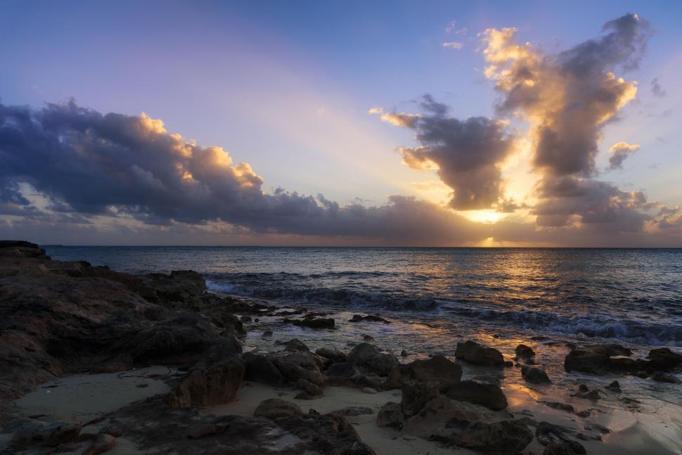 Free Image of Rocky shore with a stunning sunset on the horizon. 