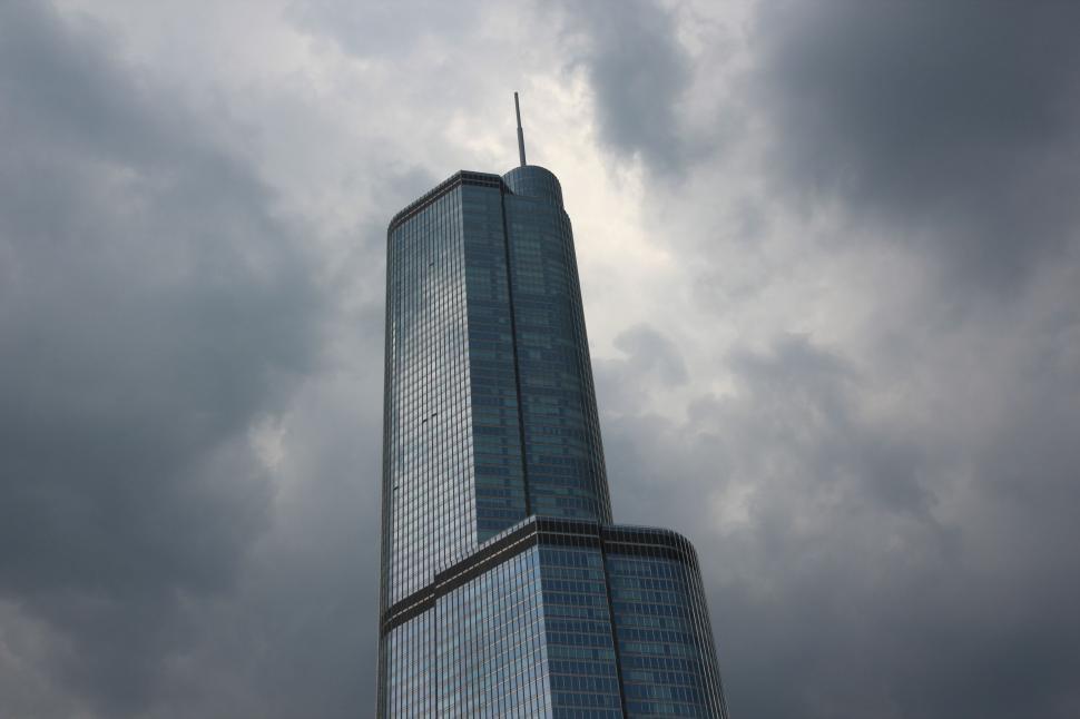 Free Image of Tall Glass Skyscraper with Dramatic Cloudy Sky Backdrop 