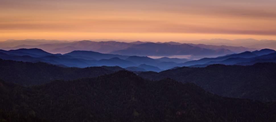 Free Image of Sunset over mountain range with layered silhouettes. 