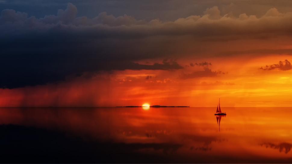 Free Image of Solitary sailboat at sunset on calm ocean horizon. 