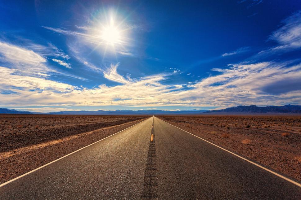 Free Image of Endless road under bright sun and clear blue sky 