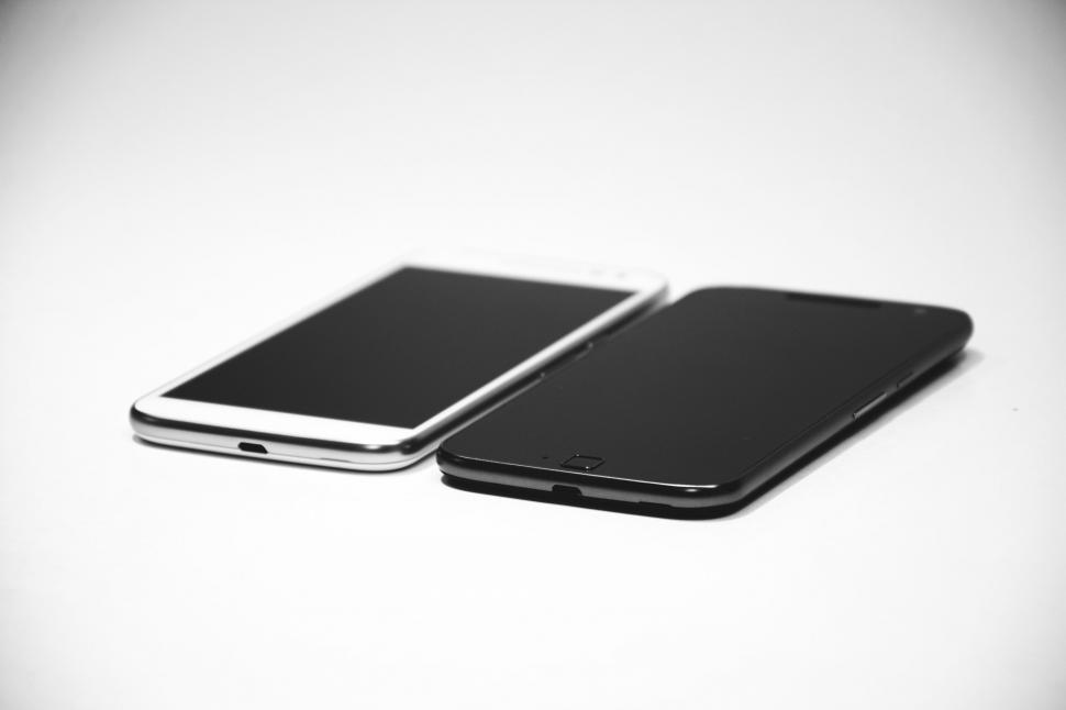 Free Image of Two smartphones placed side by side in monochrome setting 