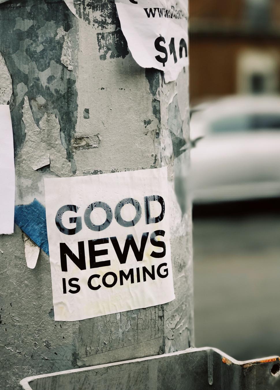 Free Image of Good news is coming poster on a street pole 