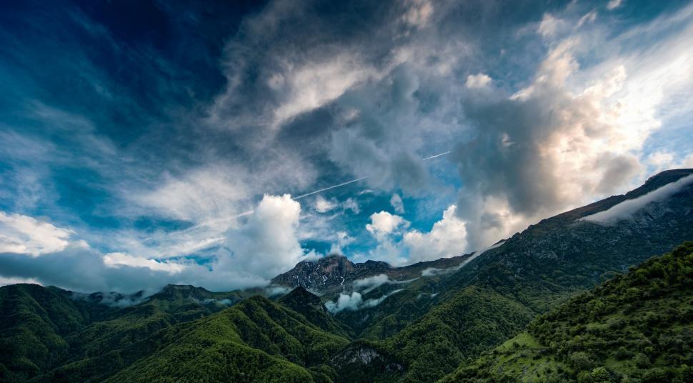 Free Image of Expansive mountain range under dramatic cloudy sky 