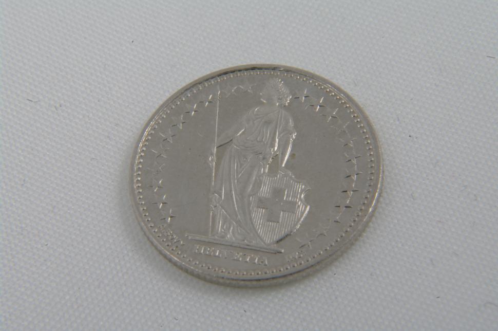 Free Image of Silver Coin Resting on White Surface 