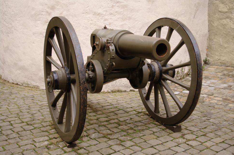Free Image of Old Cannon Resting on Cobblestone Street 