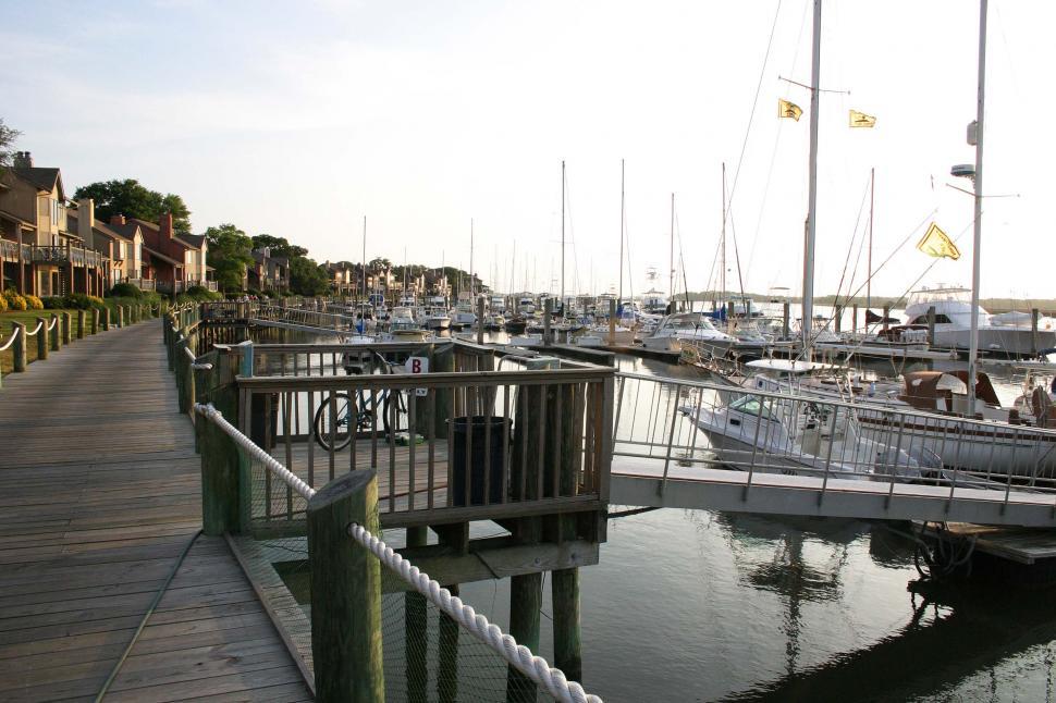 Free Image of boat dock marina boardwalk bicycle beachhouse beach house ramp railing post mast flag 