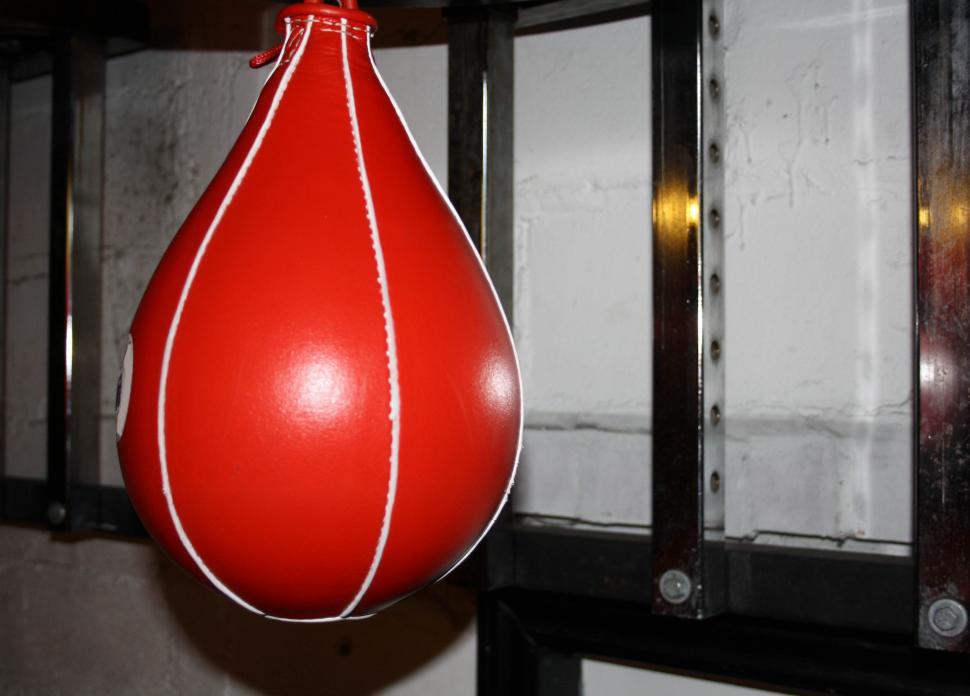 Free Image of Red Punching Bag Hanging From Metal Rack 