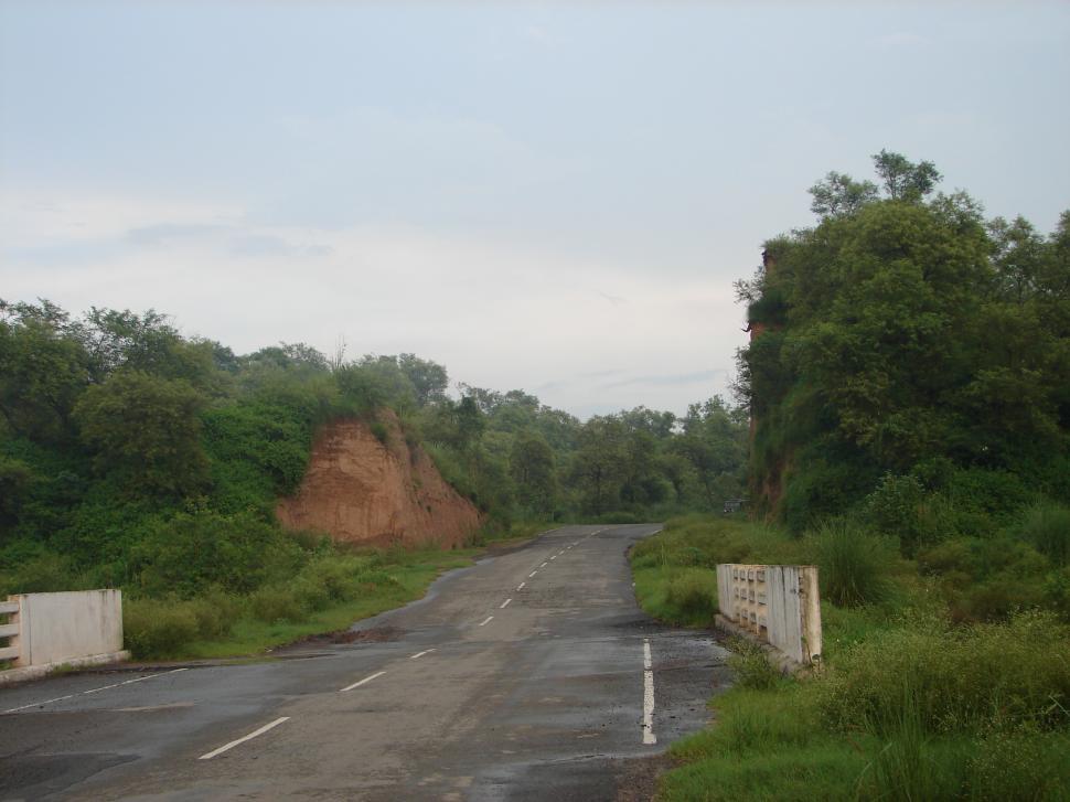 Free Image of Road With Dirt Hill in Background 