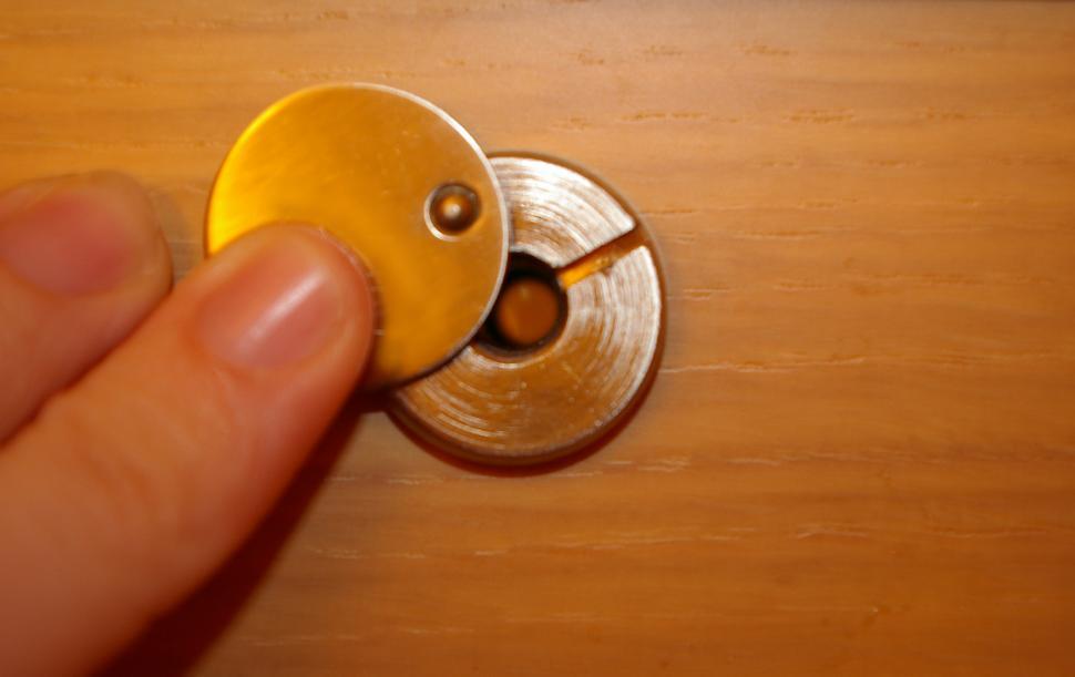 Free Image of Person Holding Yellow Button on Wooden Surface 
