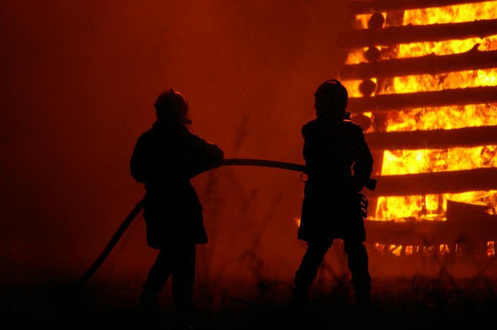 Free Image of People Standing in Front of Fire 