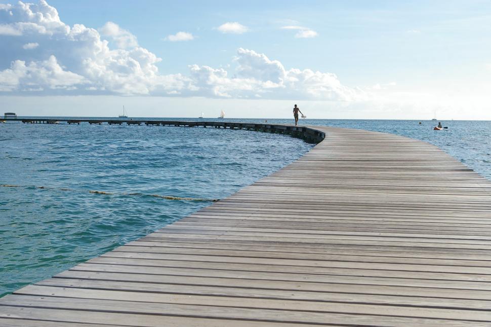 Free Image of Person Standing on Dock in Middle of Ocean 