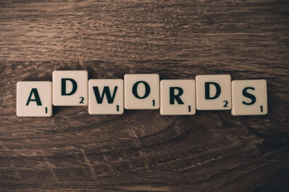 Scrabble tiles arranged to spell ADWORDS on a table.