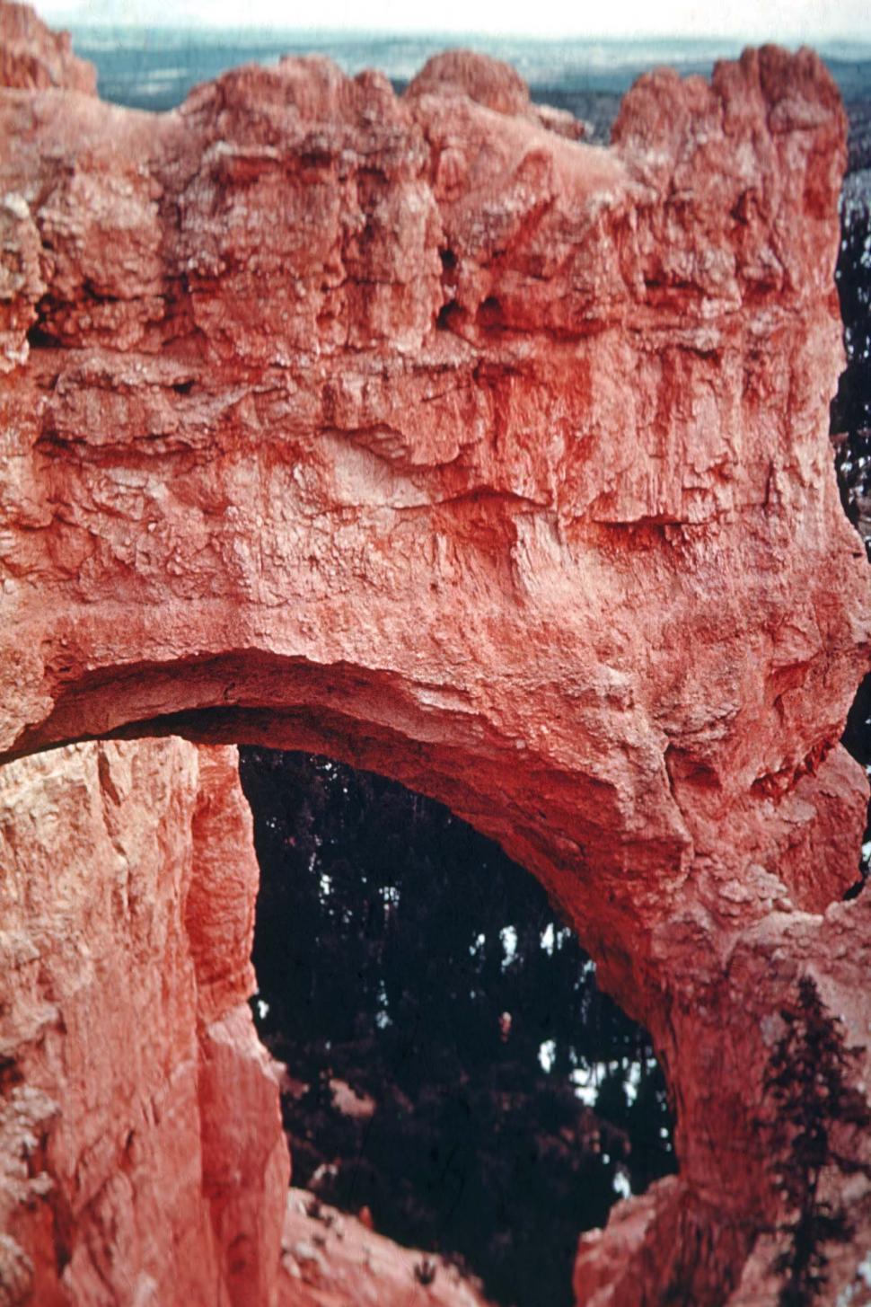 Free Image of Red Rock Formation With Trees in Background 