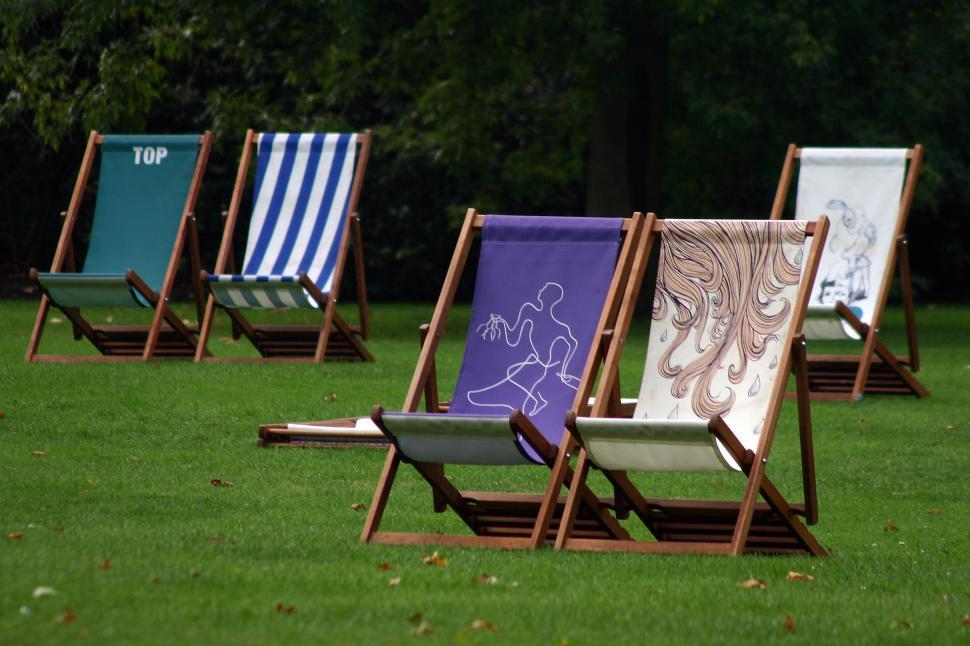 Free Image of Row of Lawn Chairs on Lush Green Field 